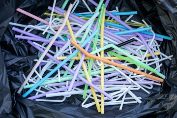Used straws in a black garbage bag