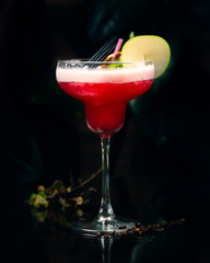 red cold cocktail with apple slice