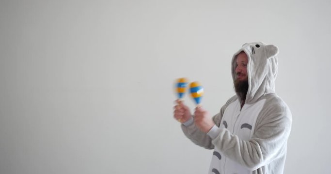 Funny bearded handsome man playing the maracas a percussion instrument often used for music education.
