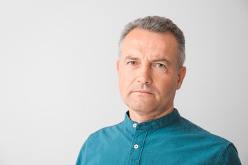 Obraz premium Portrait of stylish mature man on light background