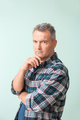 Fototapeta premium Portrait of stylish mature man on color background