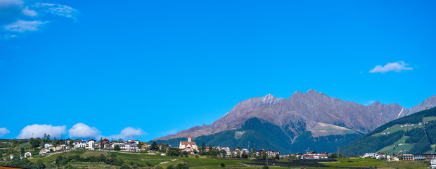 Panorama vom Dorf Tirol in Südtirol. Berge und viel blauer Himmel im Hintergrund