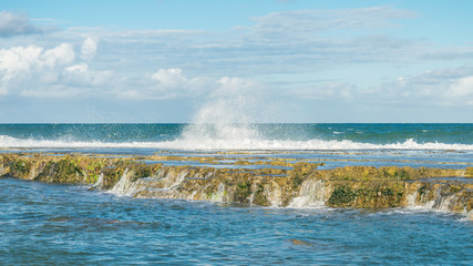Wild waves crashing on the rocky reef at the beach in Aremebe - Bahia, Brazil
