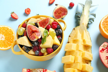 Pot with tasty fruit salad on color background