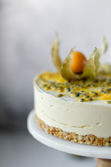 Passionfruit vegan cheesecake with Physalis on marble background with copy space