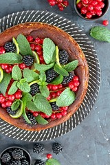 Baked cheesecake with fruits and mint. Top view with copy space.