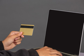 The hacker was sitting with a colored credit card on his notebook and had a gray background....