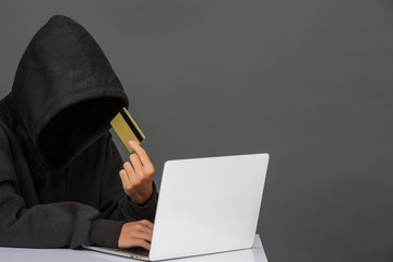 The hacker was sitting with a colored credit card on his notebook and had a gray background....
