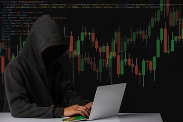 The concept of cyber theft. The hacker is using a white notebook placed on the table.