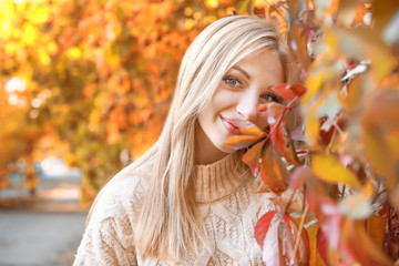 Naklejka na ściany i meble Beautiful young woman in autumn park