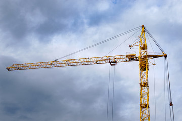 construction of houses on a cloudy day construction crane on the streets of the city
