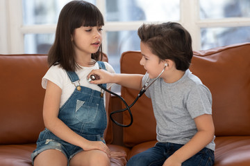 Two siblings playing hospital game at home.