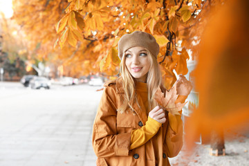 Beautiful young woman in city on autumn day