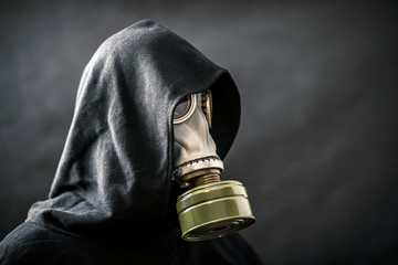 Man in a gas mask and hooded cloak. Environment pollution.