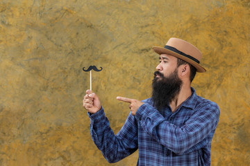 Movember Concept. Handsome young man with long beard wearing a blue long sleeved shirt, wearing a...