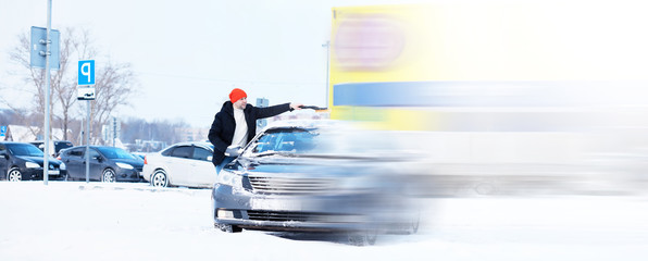 A male driver is standing in front of a car. The owner cleans the car from snow in winter. Car...