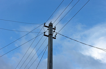 power pole with wires against a blue sky with clouds