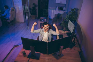 Hign angle above view photo of it skilled specialist guy sitting chair celebrating startup success looking many monitors team finished server debugging night office indoors
