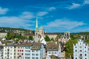 Fototapeta na wymiar View of the historic center of Zurich at the bank of Limmat River, with beautiful house rooftops and University Zurich and church of Predigerkirche, view form Lindenhof hill.