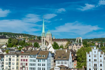 Deurstickers View of the historic center of Zurich at the bank of Limmat River, with beautiful house rooftops and University Zurich and church of Predigerkirche, view form Lindenhof hill. © zz3701