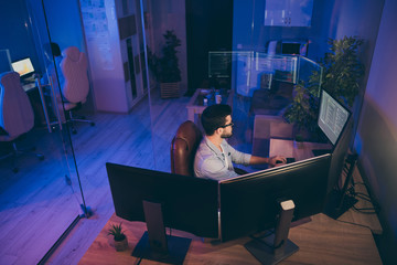 Profile photo of it specialist guy night sitting chair seriously looking many monitors writing...