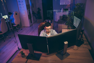 High angle view photo of it specialist guy sitting chair seriously looking many monitors testing...