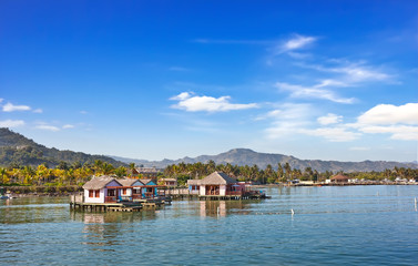Fototapeta na wymiar Cabanas on the water in luxury tropical resort on sunny day