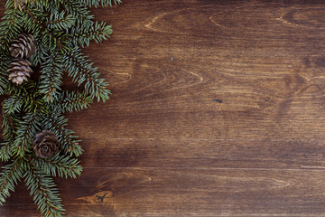 Fototapeta premium New Year's background. Spruce branches on a wooden table. Ornaments for the New Year tree. Christmas concept.