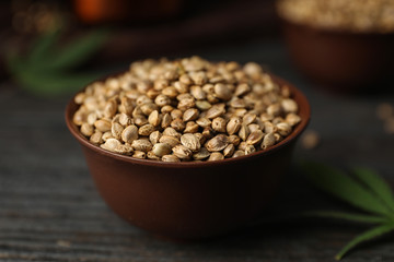 Organic hemp seeds in bowl on black wooden table