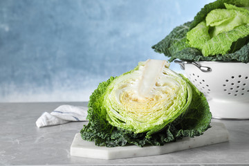 Half of fresh green savoy cabbage on table against light blue background. Space for text