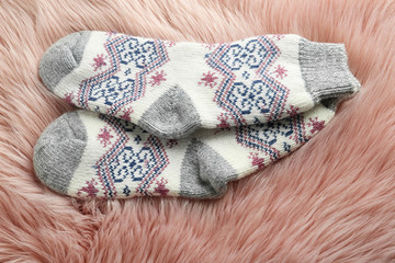 Knitted socks on pink faux fur, closeup