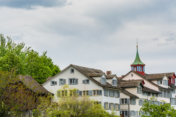 Fototapeta na wymiar View of the historic center of Zurich at the bank of Limmat River, with beautiful house rooftops in spring, view form Lindenhof hill.