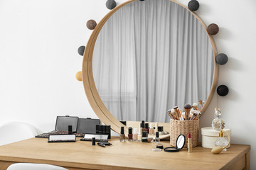 Cosmetics and brushes on dressing table in makeup room