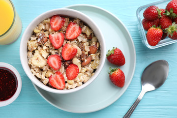 Flat lay composition with tasty muesli on light blue wooden table. Healthy breakfast