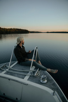 young man in a boat at sunset