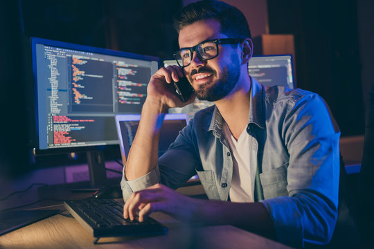 Close-up Portrait Of His He Nice Attractive Skilled Cheerful Cheery Guy Geek Tech Shark Talking On Phone With Friend Remote Help Assistance Service In Dark Room Workplace Workstation Indoors