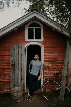 man in front of old door of a cabin