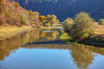 autumnal landscape with flowing river 