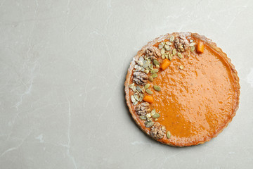 Delicious fresh homemade pumpkin pie on light grey marble table, top view. Space for text
