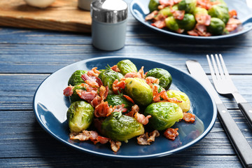 Tasty roasted Brussels sprouts with bacon on blue wooden table