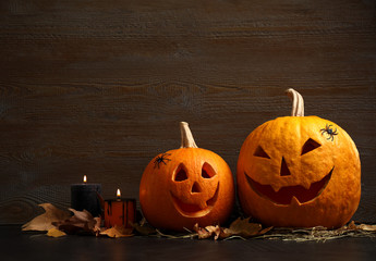 Spooky Jack pumpkin head lanterns on grey table against wooden background, space for text. Halloween decoration