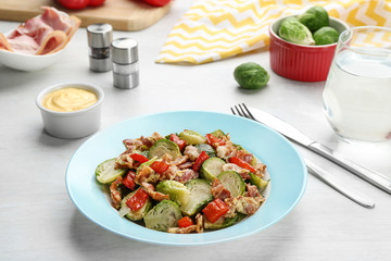 Delicious cooked Brussels sprouts with bacon served on white table