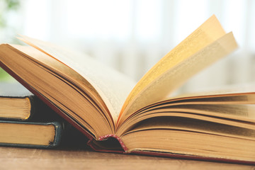 Open hardcover book on wooden table indoors, closeup
