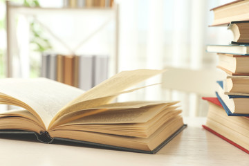 Open hardcover book on white wooden table indoors