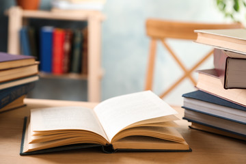 Open hardcover book on wooden table indoors. Space for text