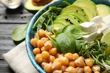 Delicious avocado salad with chickpea on black table, closeup