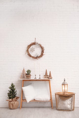 Console table with Christmas decoration near brick wall. Idea for festive interior