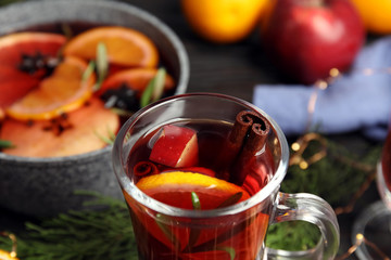 Tasty mulled wine with spices on table, closeup