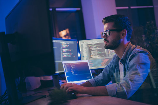 Profile side view portrait of his he nice attractive skilled focused serious guy writing script ai tech support devops creating digital solution front-end in dark room workplace station indoors