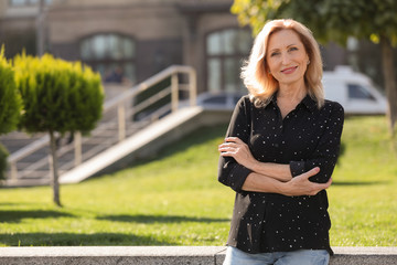 Portrait of happy mature woman in park on sunny day